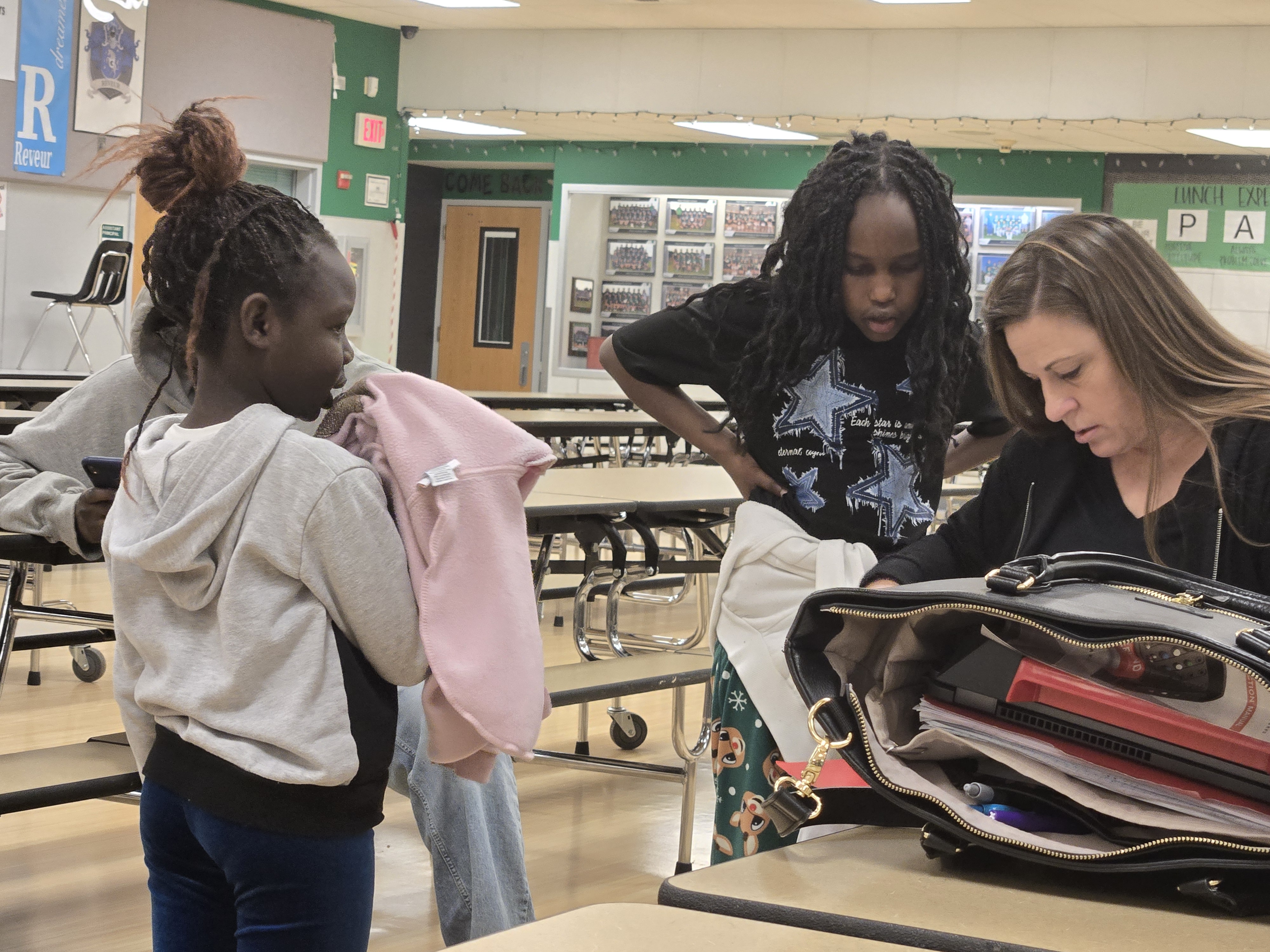 SDM volunteer helping two young girls with their schoolwork